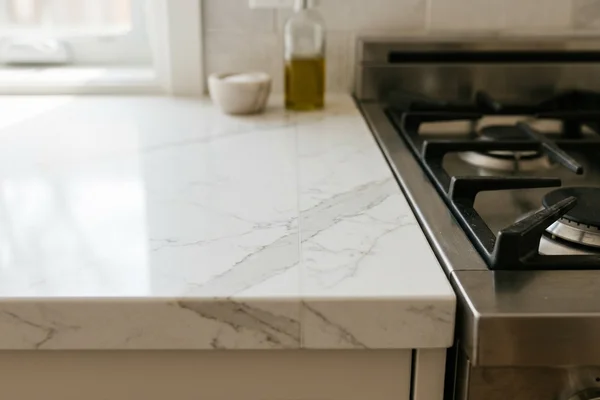Colour-matched epoxy seam on a quartz countertop behind a range