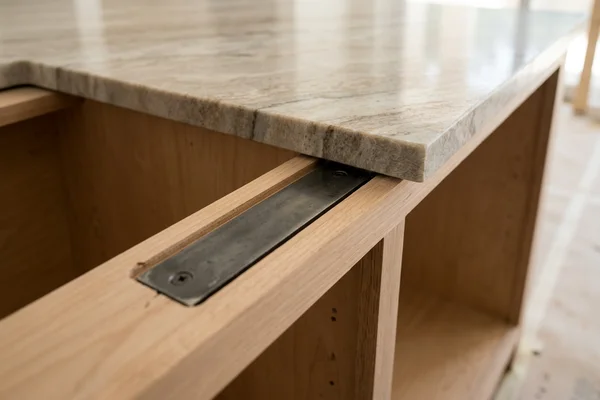 Recessed steel brackets in an island cabinet rail before the quartz top