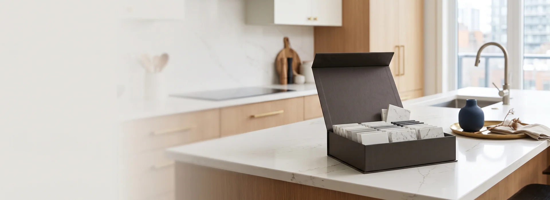 Quartz sample box with Caesarstone, Cambria and Hanstone colour chips on a kitchen island